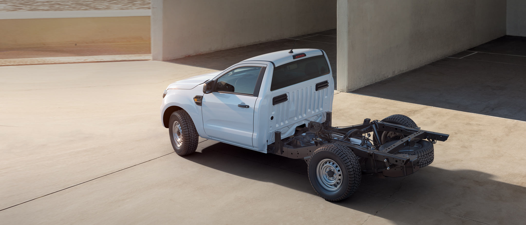 Ford Ranger Einzelkabine Fahrgestell Weiß 3/4-Seitenansicht in der Vogelperspektive, vor Halle parkend