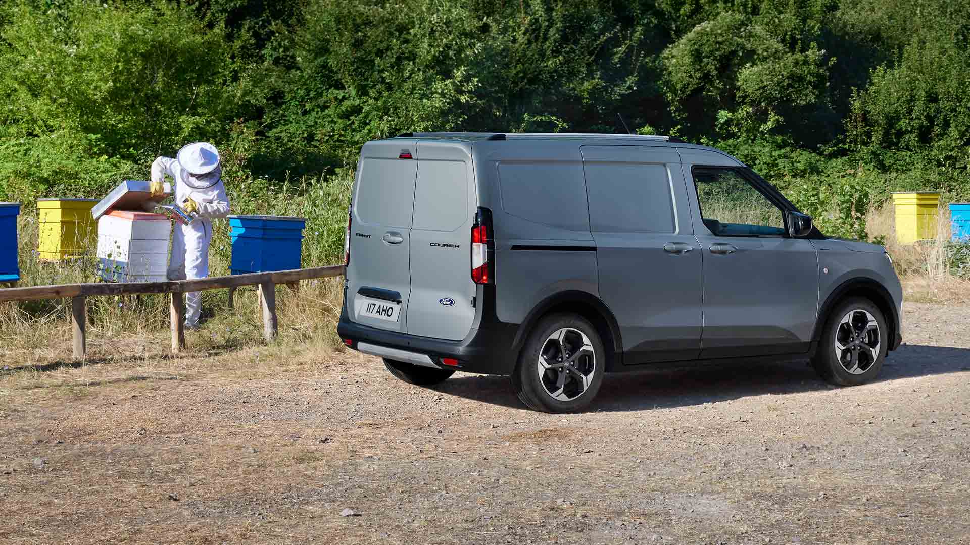 Imker arbeitet neben einem neuen Ford Transit Courier