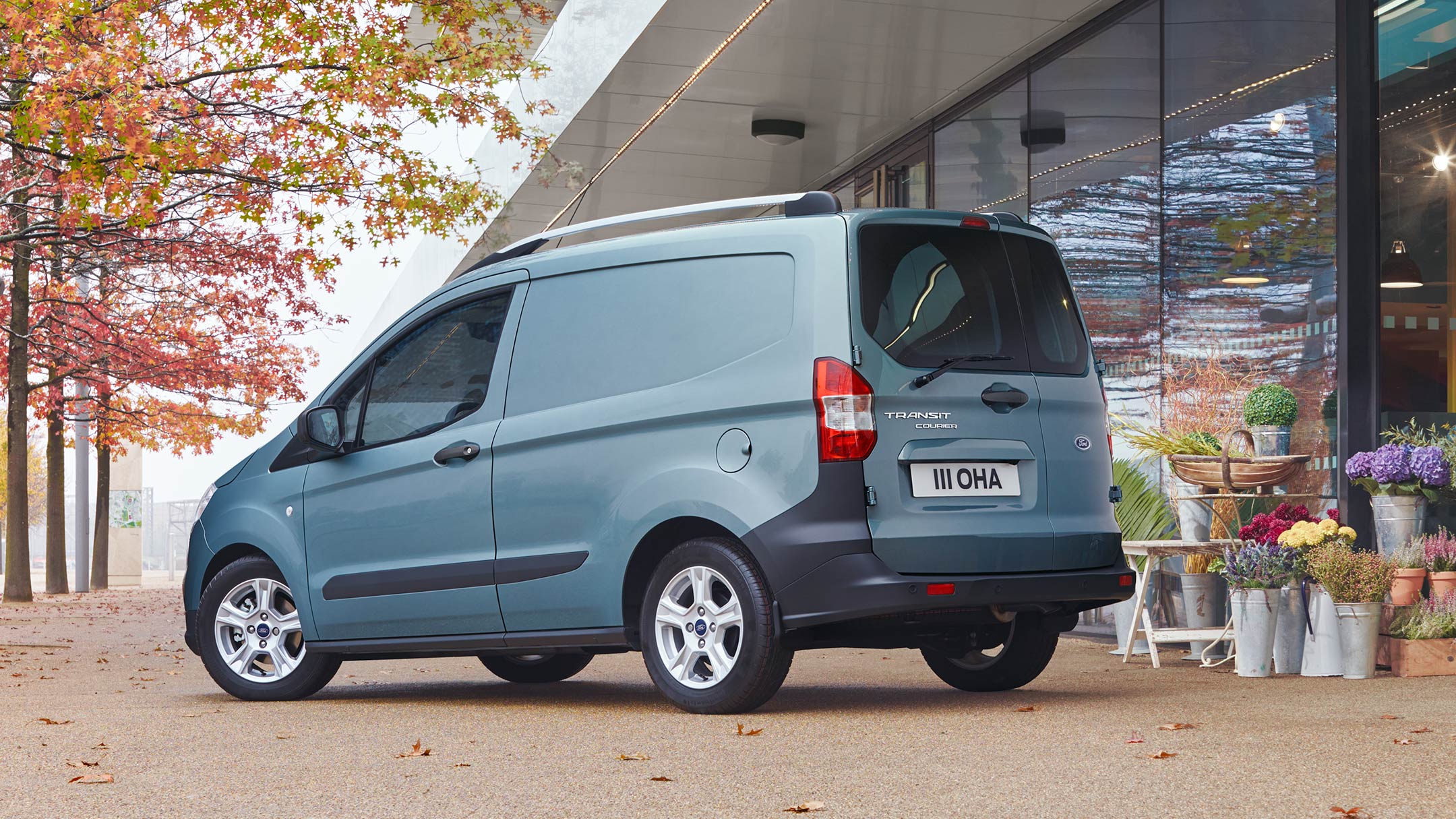 Ford Transit Courier Blau ¾-Seitenansicht geöffnete Hecktür wird vor Blumengeschäft entladen