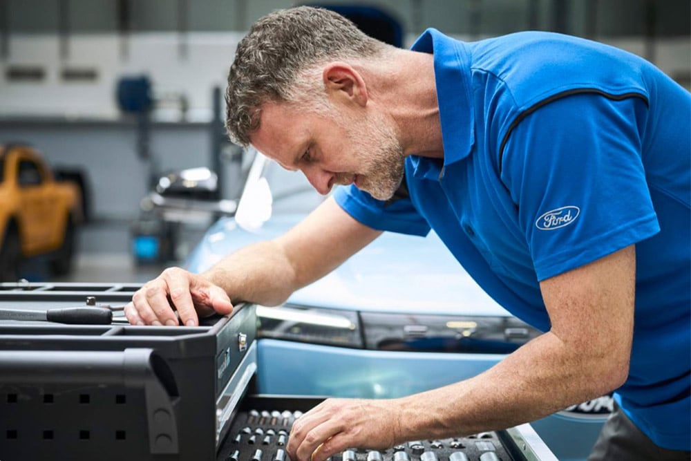 Nahaufnahme eines von Ford zertifizierten Technikers bei der Arbeit in einer Werkstatt.