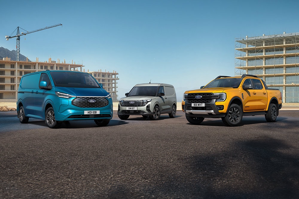 Eine Ansammlung von Ford-Fahrzeugen, die vor einer Baustelle geparkt sind.