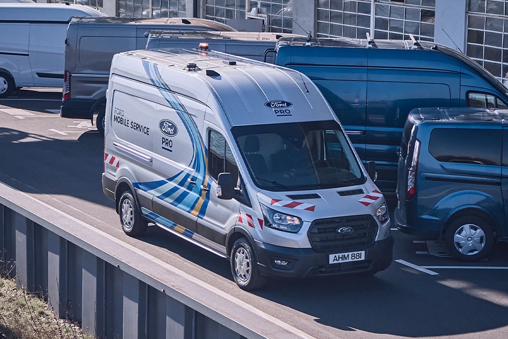 A white Ford Pro Mobile Service van parked in a van lot.