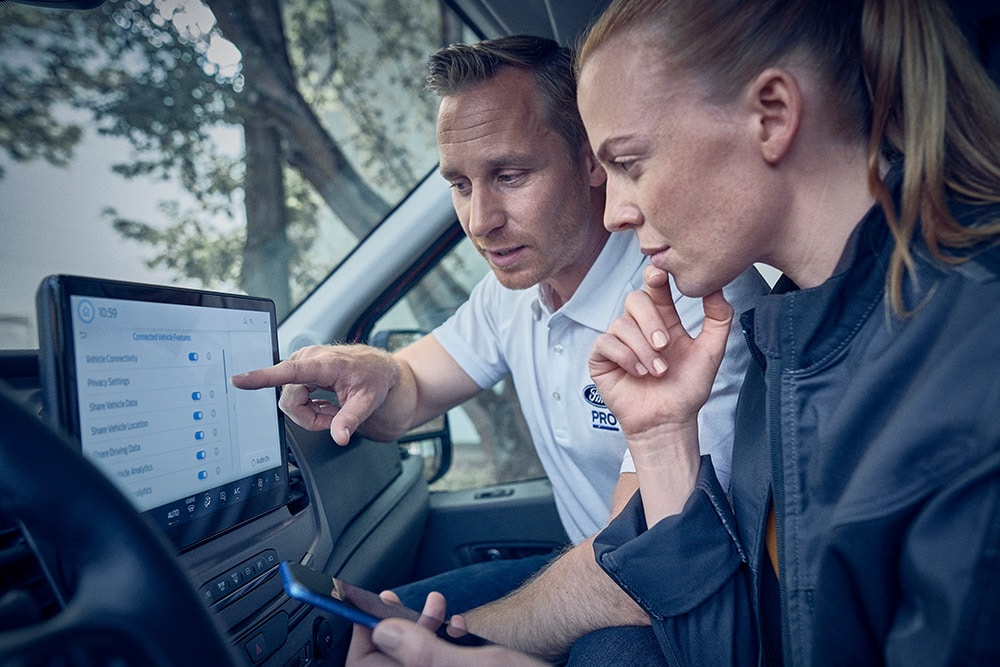 Mehrere elektrische Ford-Flottenfahrzeuge parken vor einem Lagerhaus.