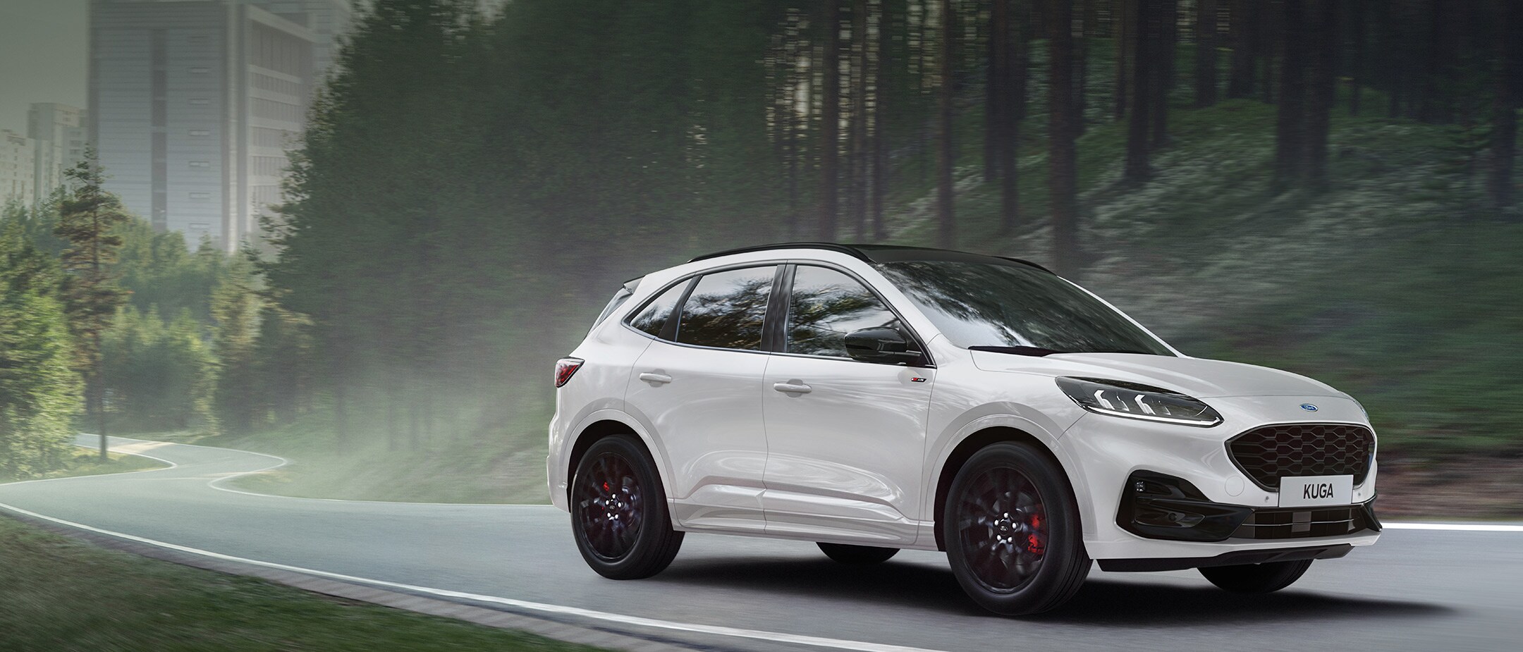 Ford Kuga ¾-Frontansicht in Graphite Edition, auf einer Straße vor Küstenlandschaft fahrend