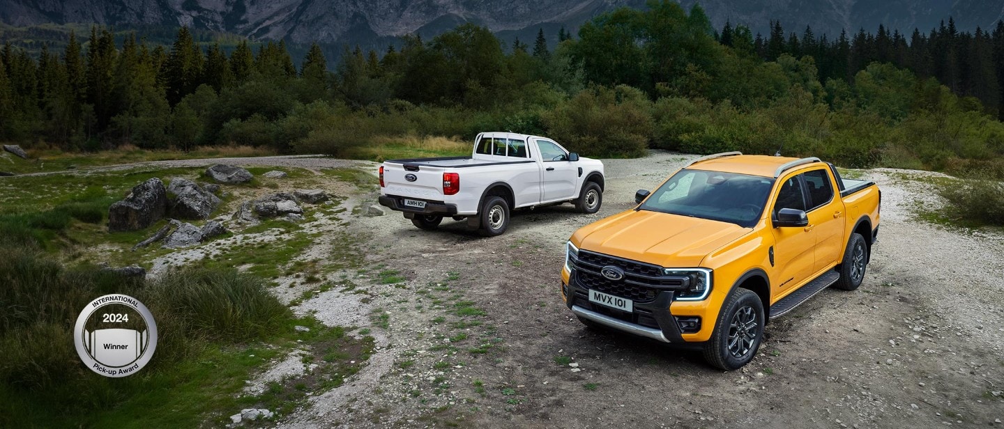 Ford Ranger-E ¾-Frontansicht in Orange, durch eine Pfütze innerhalb eines Steinbruchs fahrend