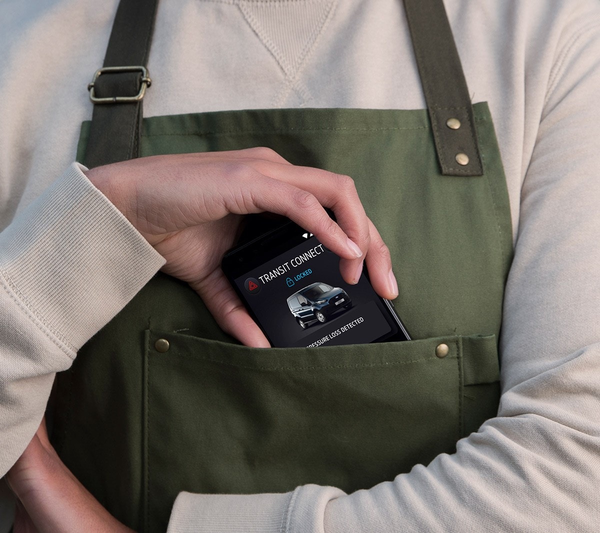 Nahaufnahme wie eine Hand ein mobiles Telefon in eine Kitteltasche steckt