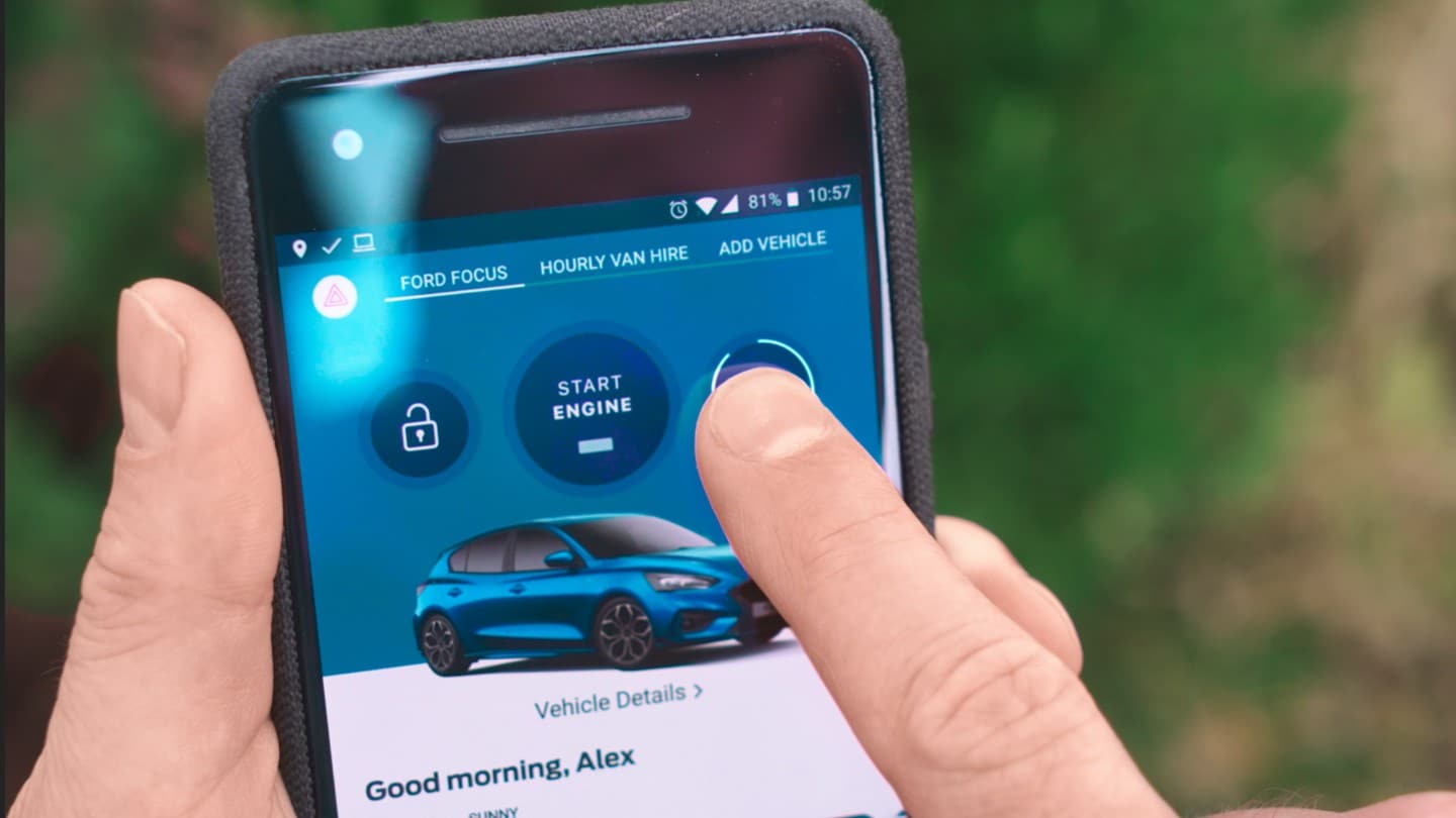 Detailansicht einer Hand, die ein Smartphone mit FordPass App hält