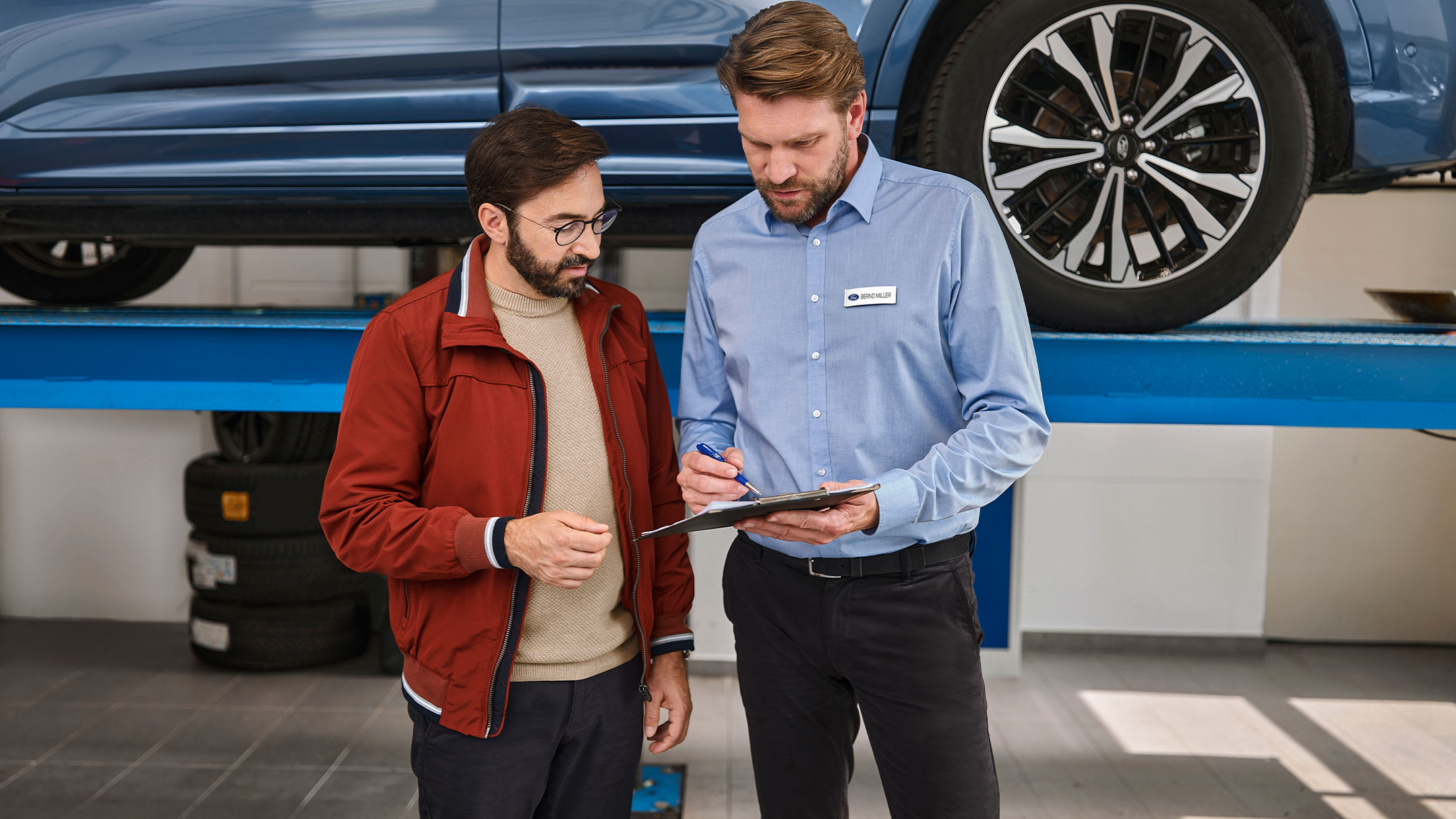 Ein Gespräch zwischen einem Kunden und Ford Service Experten in der Werkstatt eines Ford Partners.