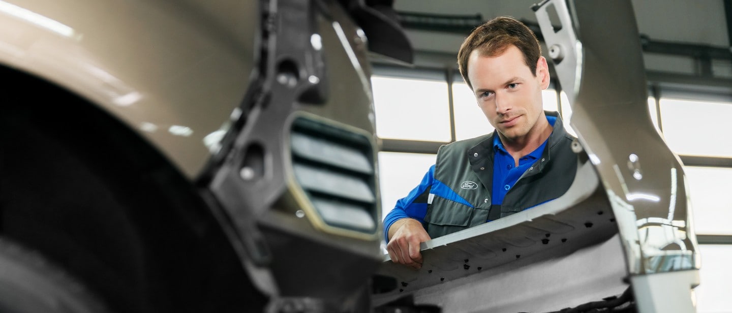 Ford-Servicetechniker beim Austausch der vorderen Stoßstange