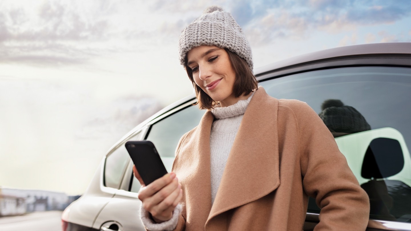 Lächelnde Frau, die auf ihr Smartphone schaut