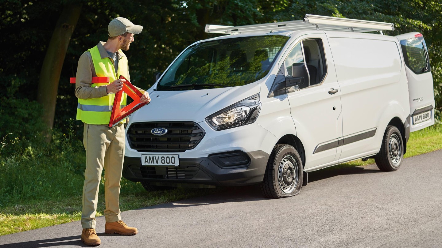 Ford-Assistance Mitarbeiter stellt Warndreieck auf