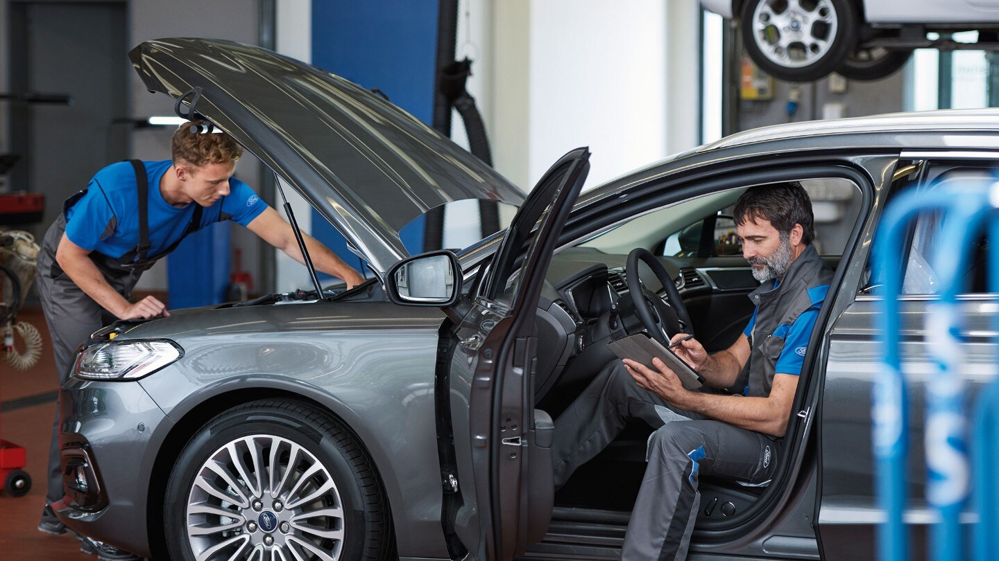 Zwei Techniker, die eine Fahrzeugkontrolle durchführen