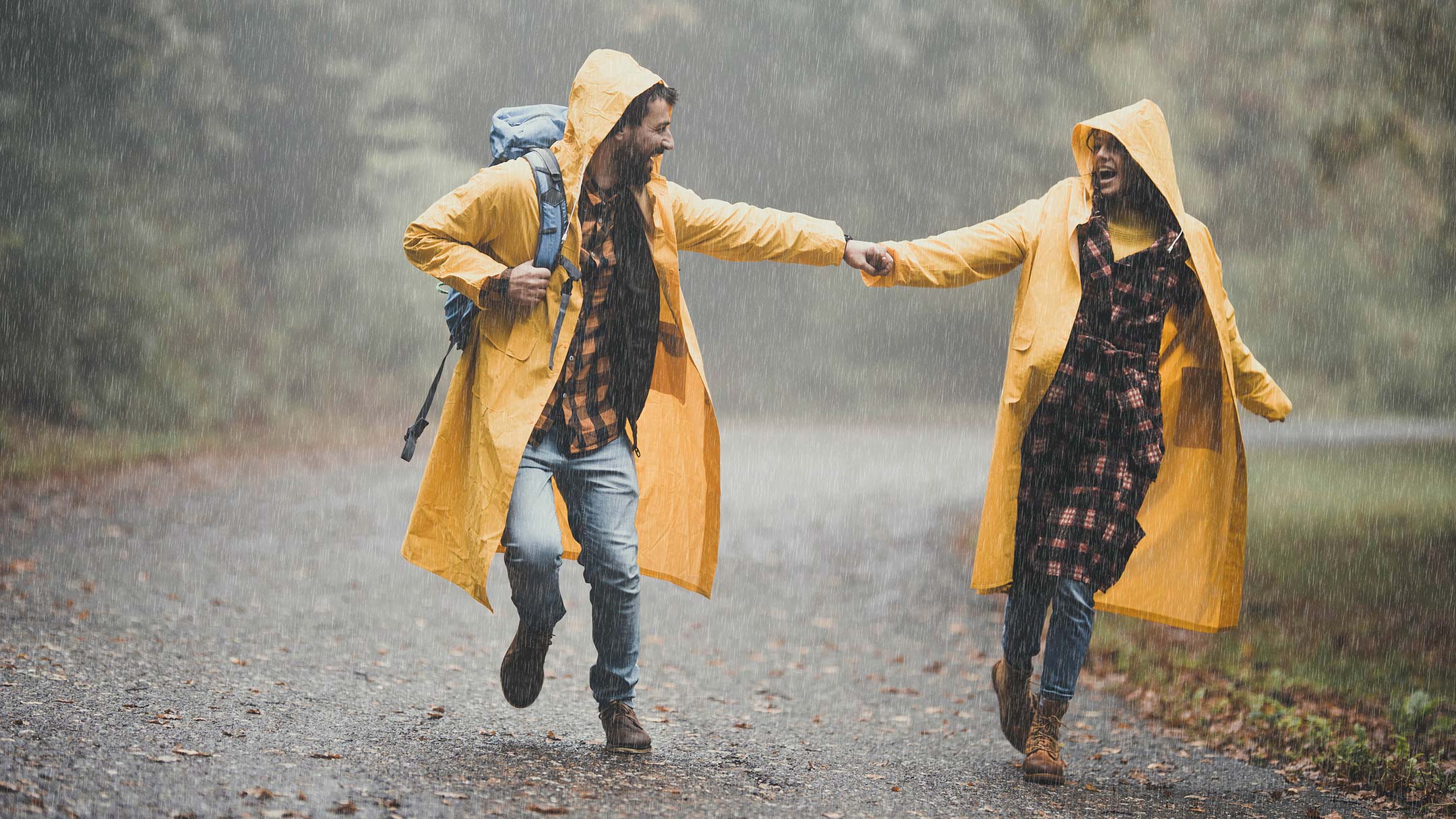 Happy couple walking while raining