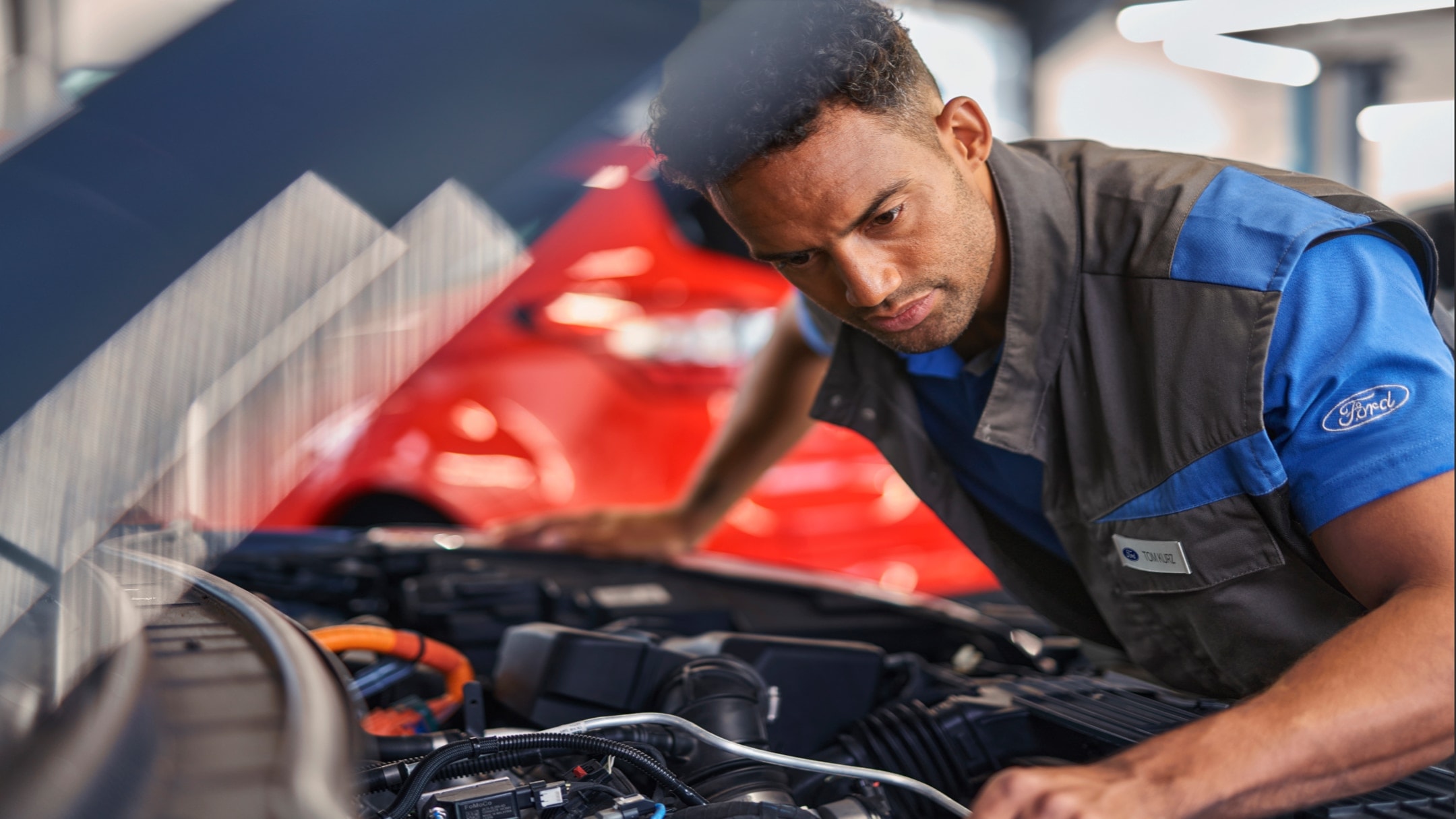 Ford technician checking under the bonnet of a Ford vehicle during a Ford Economy Service