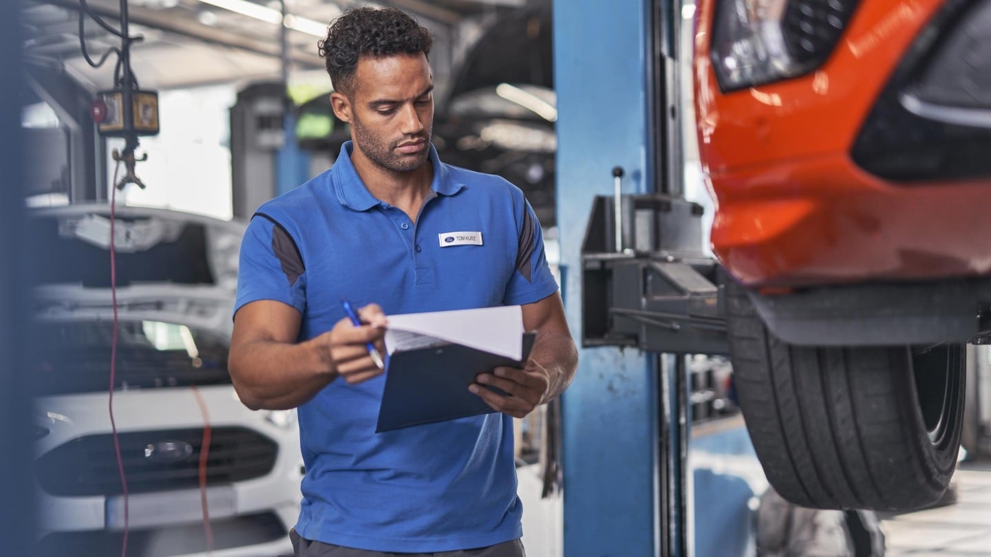 Ein Ford Service Ingenieur inspektiert Reifen 
